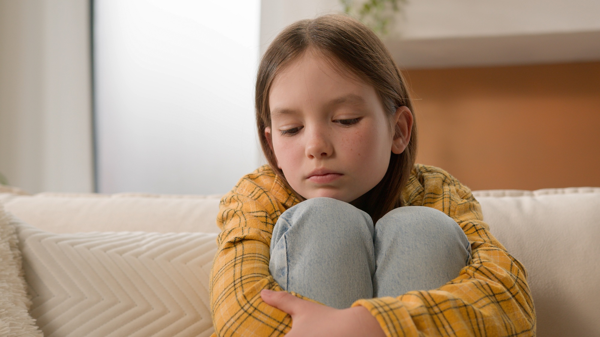 Stressed unhappy sad pensive Caucasian kid little girl feeling frustrated depressed lonely hugging